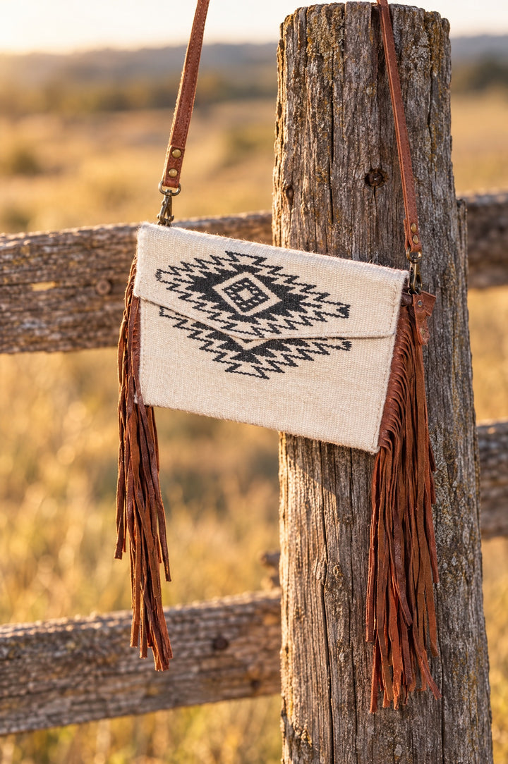 Aztec crossbody purse hanging on a fence post