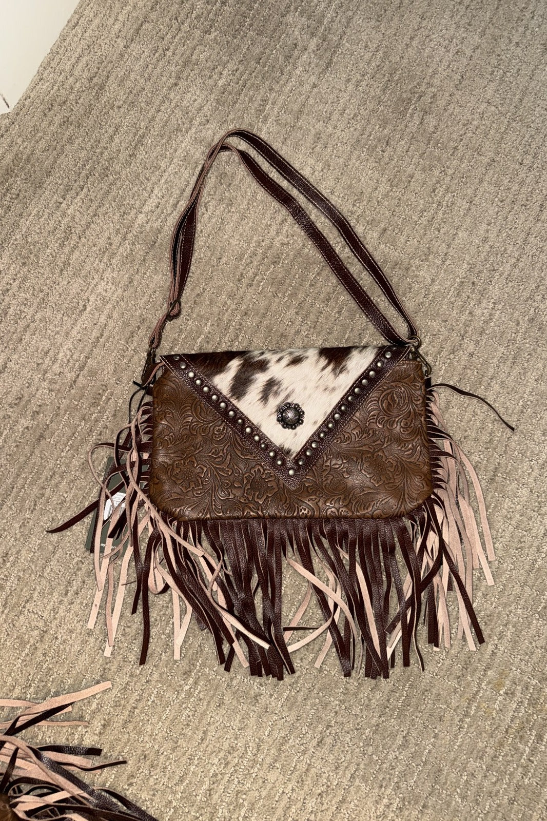 Dusky fringe handbag with spotted cowhide flap, studs, concho and shoulder strap