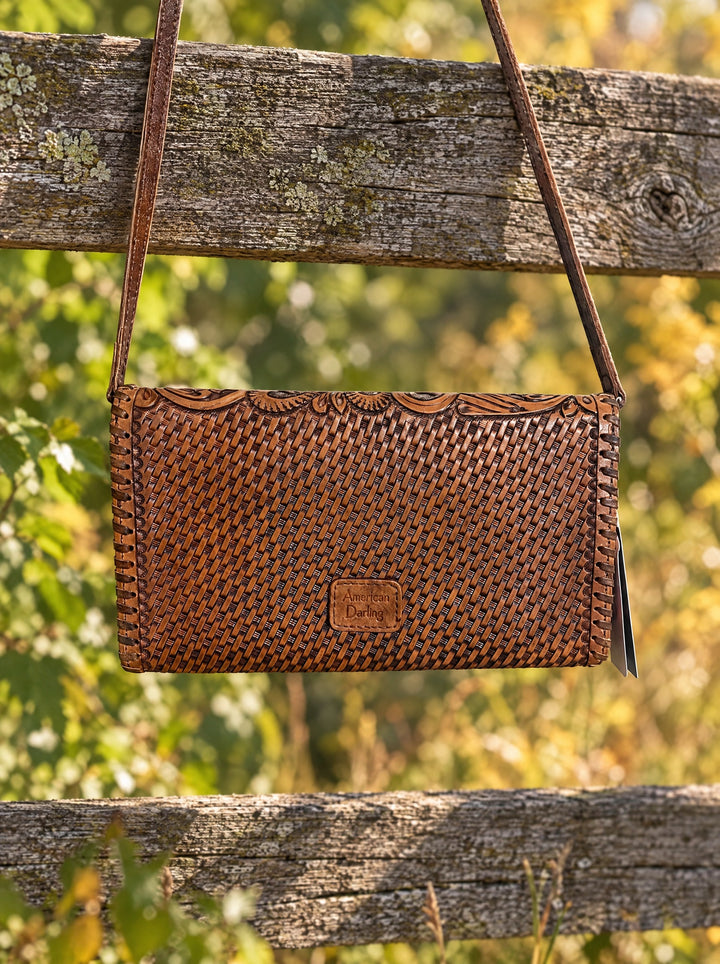 Free And Wild tooled leather bag hanging on a fence