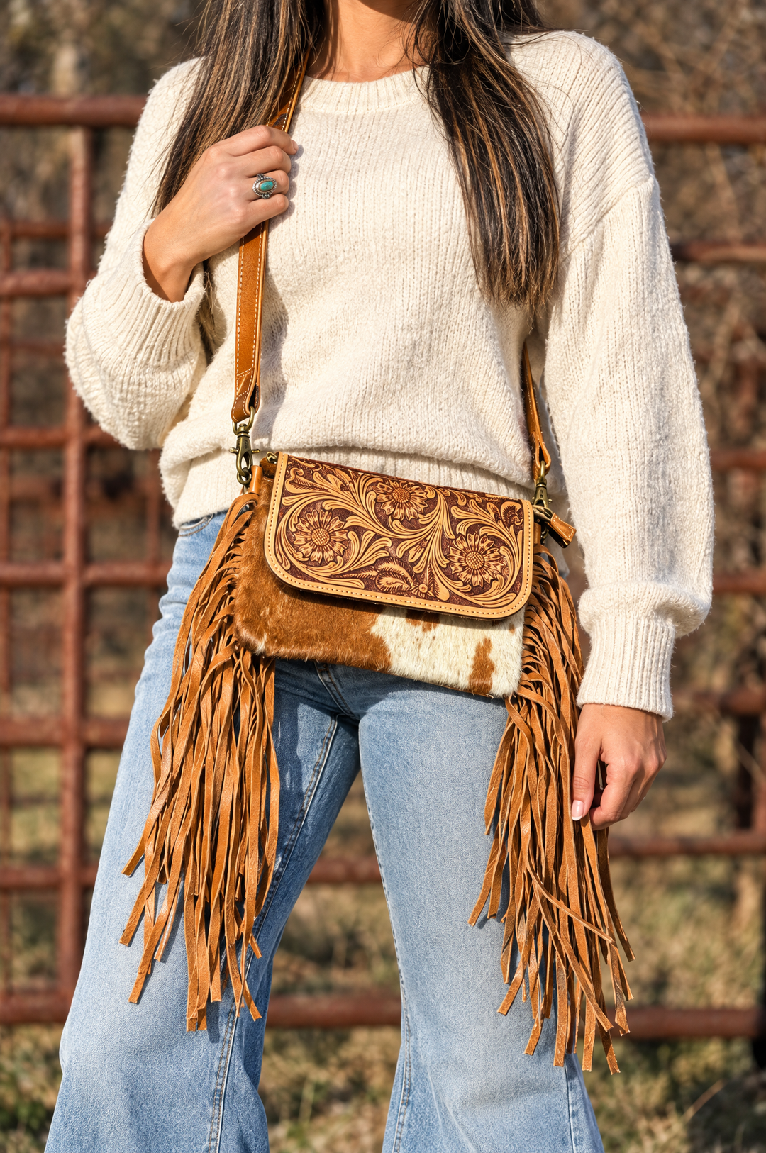 Tooled leather fringe crossbody worn with cream sweater