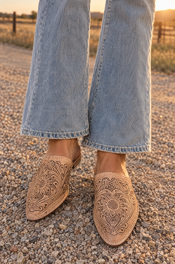 Tooled leather pointed toe mules worn with flare jeans