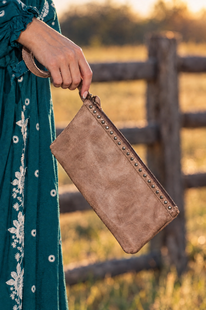 Brown leather wristlet carried by the wrist strap