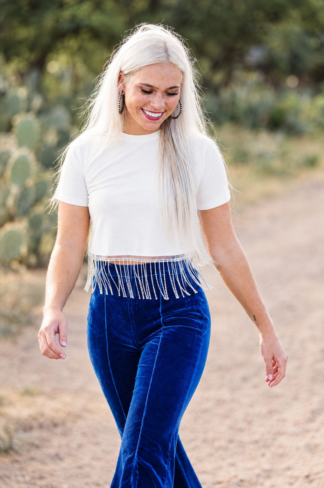 White rhinestone fringe crop top on model walking